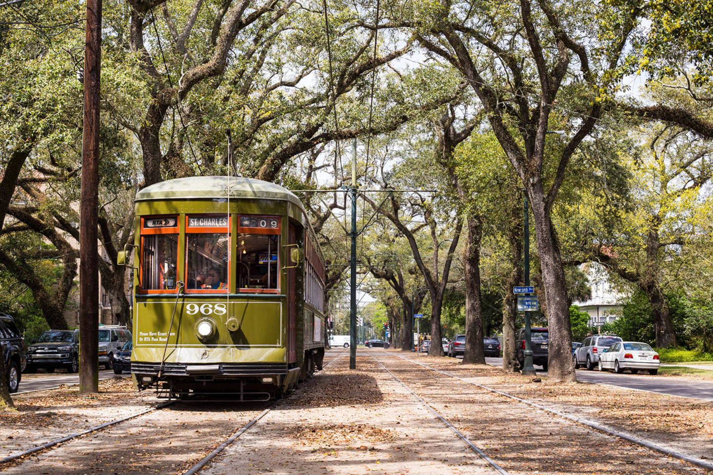 green streetcar on tree lined street