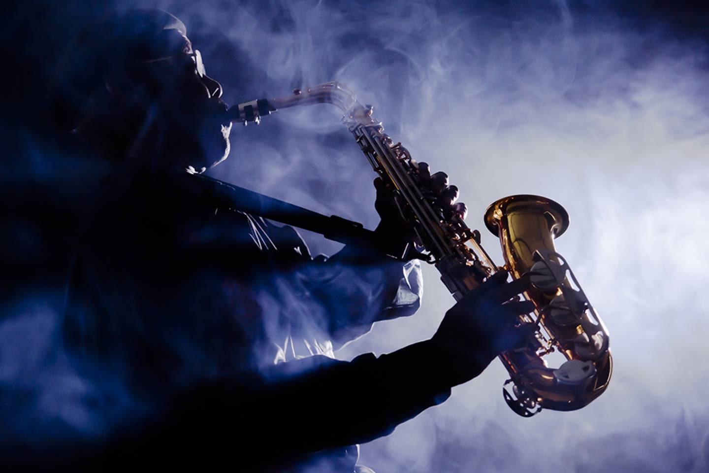 silhouette of man playing saxophone