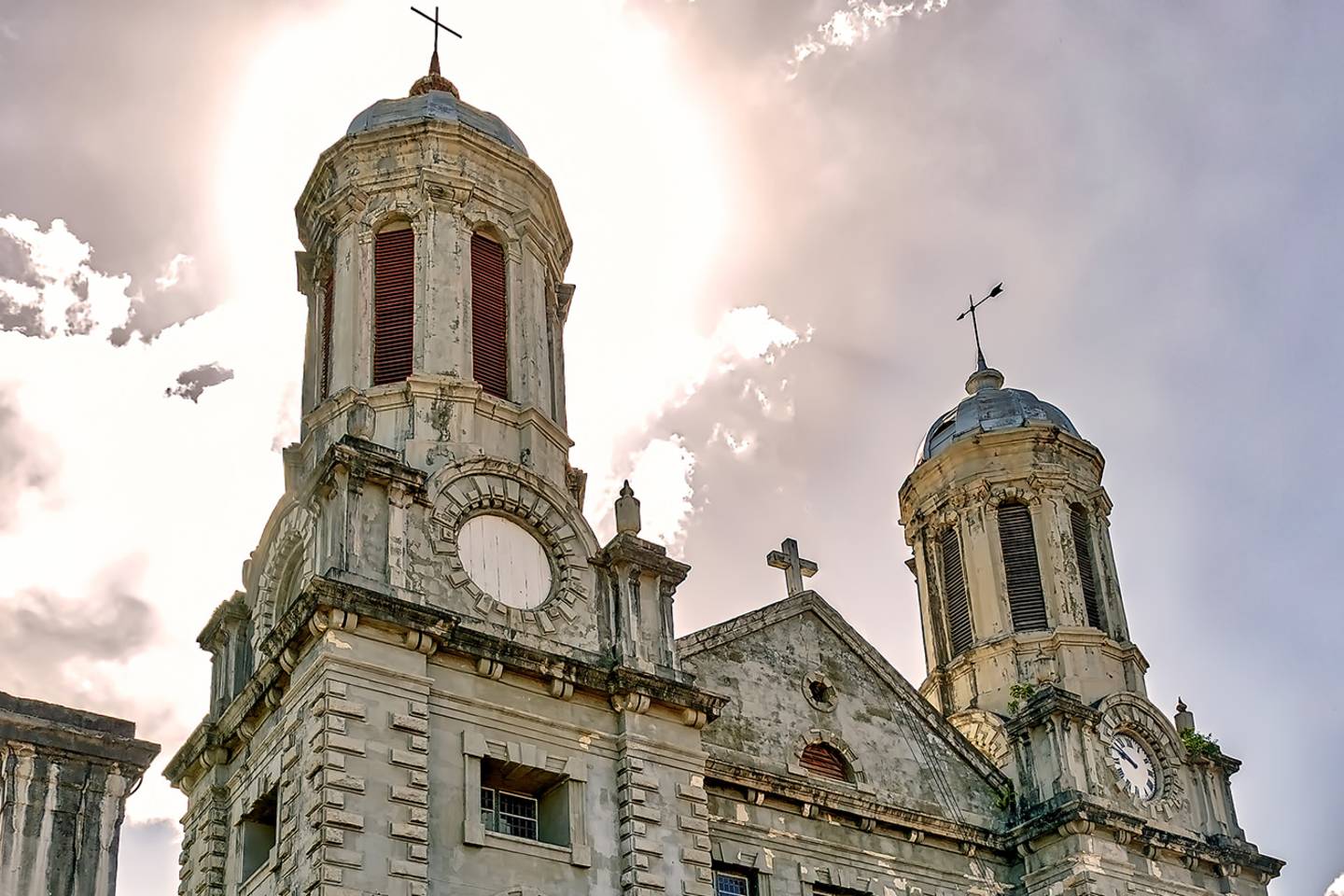 church with two towers with sun behind